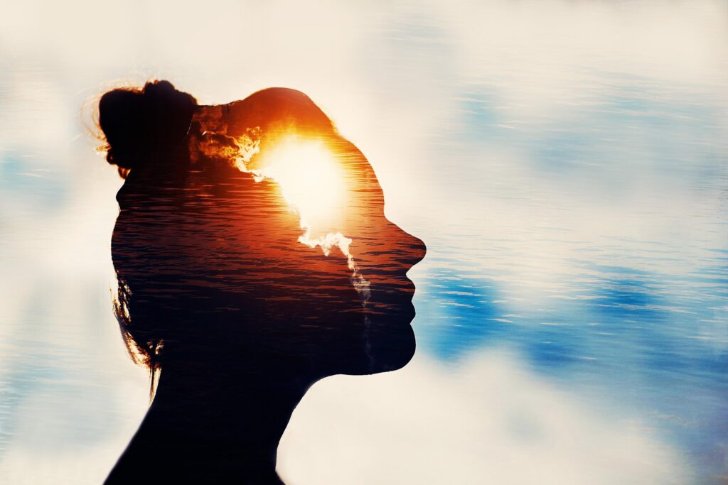 Silhouette of a woman's profile with a sunrise inside her head